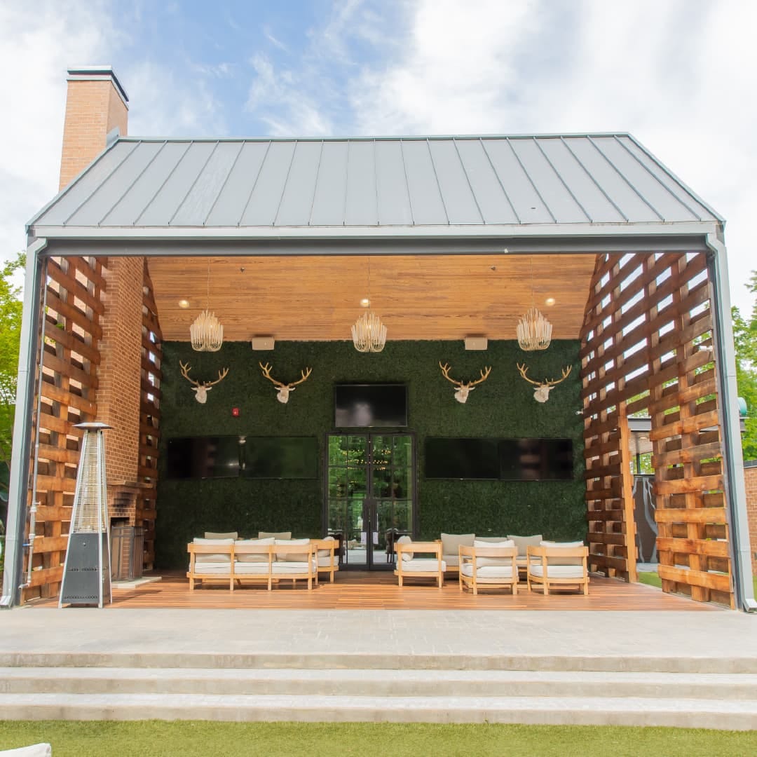 Alice Veranda outdoor private dining space at The Grove Kitchen & Gardens in Tyler, Texas with fireplace, sitting areas, and lawn views