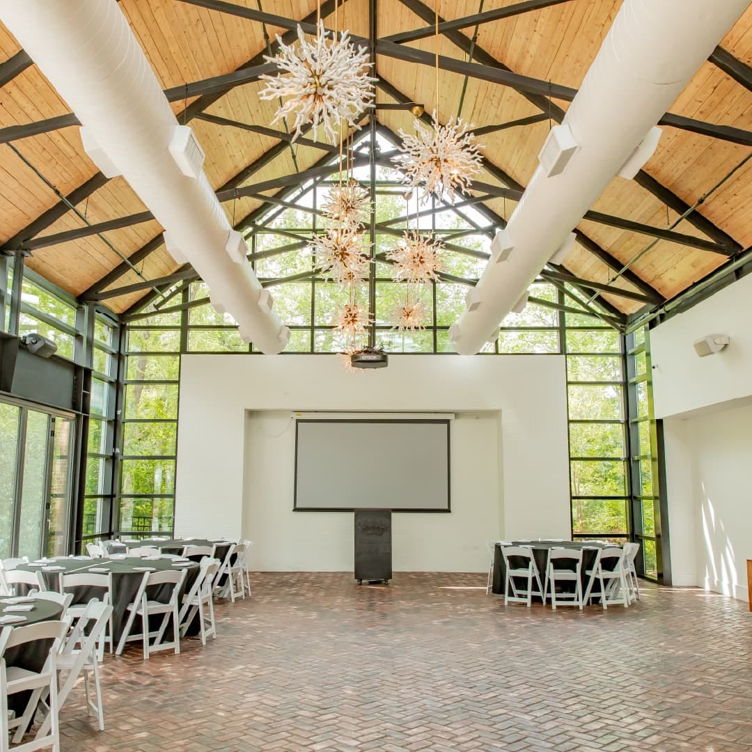 The Greenhouse at The Grove Kitchen & Gardens in Tyler, Texas, a glass-paned event space filled with natural light for seated dinners and standing receptions